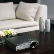 A photograph of a Panasonic PT-AE500 projector - coffee table, floor, flooring, furniture, product design, table, gray, black