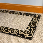view of textured carpet with a black boarder flooring, mat, orange