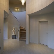 A overview of the curved staircase whch leads apartment, architecture, ceiling, daylighting, estate, floor, flooring, home, house, interior design, lobby, real estate, stairs, tourist attraction, wall, window, gray