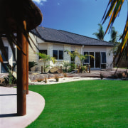 View of the outdoor area of this home backyard, cottage, estate, facade, grass, home, house, landscape, landscaping, lawn, outdoor structure, plant, property, real estate, residential area, roof, siding, yard, black, green