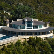 A high shot of a large cliff top architecture, building, estate, home, house, mansion, property, real estate, residential area, villa, brown