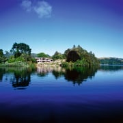 View of lakeside property. House is surrounded by atmosphere, bank, body of water, calm, cloud, daytime, grass, horizon, lake, landscape, loch, morning, nature, pond, reflection, reservoir, river, sky, tree, water, water resources, watercourse, waterway, wetland, blue, teal