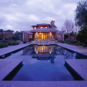 View of the pool in front of two architecture, estate, evening, home, house, lighting, mansion, property, real estate, reflection, residential area, sky, swimming pool, villa, blue