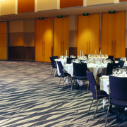 Large function room with cream and grey patterned carpet, conference hall, floor, flooring, function hall, interior design, restaurant, table, brown, orange