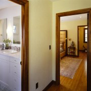 View of the doorways to the bathroom and bathroom, door, estate, floor, flooring, home, interior design, property, real estate, room, suite, wood, wood flooring, brown, gray