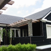 View of the landscape of this modern home cottage, facade, home, house, outdoor structure, porch, property, real estate, residential area, roof, siding, window, black, white