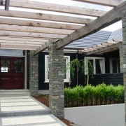 View of the pergole that has stone pillars home, house, outdoor structure, patio, porch, property, real estate, residential area, roof, siding, walkway, gray