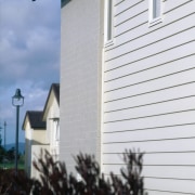 View of the cladding - View of the architecture, building, facade, home, house, property, real estate, residential area, siding, sky, structure, window, white