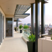 Wrap-around balcony of apartment with paving, glass balustrades, daylighting, floor, interior design, real estate, window, white