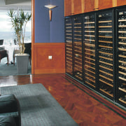 Wine storage cabinets along wall with seating area, floor, flooring, furniture, interior design, wood, black