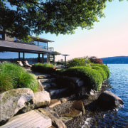 View of the waterfront property - View of cottage, home, house, plant, real estate, reflection, shore, sky, tree, water, black, white