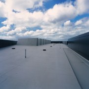 Waterproof roofing has been used on this section architecture, asphalt, cloud, daylighting, daytime, fixed link, horizon, infrastructure, line, road, road surface, roof, sky, sunlight, gray