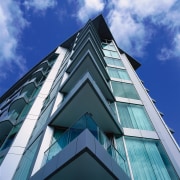 Exterior view of apartment building, looking up at angle, architecture, building, commercial building, condominium, corporate headquarters, daylighting, daytime, elevation, facade, house, line, sky, symmetry, blue