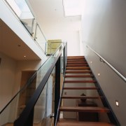 A stairway in a penthouse suite with timber architecture, daylighting, floor, glass, handrail, stairs, structure, brown, white