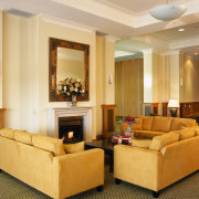 Lounge area with yellow toned lounge suite positioned ceiling, floor, flooring, furniture, interior design, living room, lobby, room, suite, wall, orange