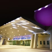 Night view of entrance of convention centre, with architecture, ceiling, daylighting, lighting, structure, black