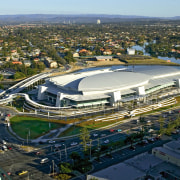 Large multi-purpose centre with expansive grey roof, with aerial photography, bird's eye view, city, sport venue, structure, urban area, water, water resources