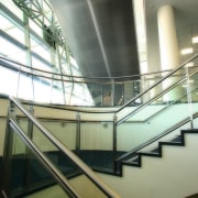 Stairway  and escalator area of building showing angle, architecture, building, condominium, daylighting, daytime, escalator, glass, handrail, line, metropolitan area, stairs, structure, brown, white