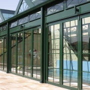 Side view of glass structure with pool inside, architecture, door, facade, fence, glass, iron, structure, window, gray