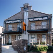 View of a large brick house, many steel building, condominium, facade, home, house, mixed use, property, real estate, residential area, teal