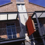 View of the balcolnies on the brick house, apartment, architecture, balcony, brick, building, daylighting, facade, home, house, neighbourhood, property, real estate, residential area, roof, sky, town, window, blue, black