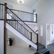 Open stairwell with ornate balustrades, white walls and architecture, baluster, ceiling, daylighting, estate, handrail, home, house, interior design, real estate, stairs, wall, gray