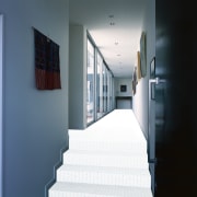 View of hallway with neutral toned carpet, blue architecture, daylighting, floor, house, interior design, window, white
