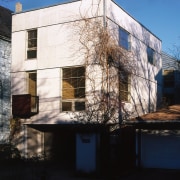 Exterior view of a white cubic house, many apartment, architecture, building, facade, home, house, neighbourhood, real estate, reflection, residential area, sky, wall, window, black