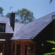 Exterior of house with brick cladding and steep cottage, daylighting, home, house, outdoor structure, real estate, roof, sky, wood, black, teal