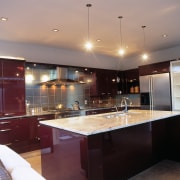 Kitchen with red brown cabinetry, stainless steel refrigerator cabinetry, ceiling, countertop, interior design, kitchen, real estate, room, under cabinet lighting, gray, red