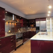 Kitchen with red brown cabinetry, stainless steel appliances cabinetry, ceiling, countertop, cuisine classique, interior design, kitchen, real estate, room, under cabinet lighting, red