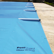 Blue swimming pool cover with aluminium tubes. - aqua, azure, blue, green, line, sky, swimming pool, tarpaulin, turquoise, water, wood, teal, orange