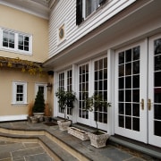Exterior view of the patio area, large French building, courtyard, door, facade, home, house, outdoor structure, porch, siding, window, gray, black