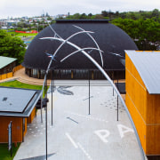 Paved area between buildings with tall sculpture, timber architecture, daylighting, facade, house, roof, shed, structure, white