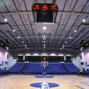 View of indoor basketball court with blue seating arena, auditorium, basketball court, ceiling, games, leisure centre, sport venue, sports, stadium, structure, gray