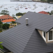 View of roof of house featuring grey roof daylighting, facade, home, house, outdoor structure, real estate, residential area, roof, siding, gray