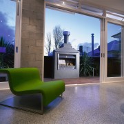 Living room area with concrete floor, green armchair, floor, furniture, hearth, home, house, interior design, living room, property, real estate, window, gray