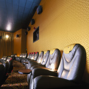 Cinema theatre with armchairs, yellow wall panels and ceiling, interior design, lighting, room, black, orange