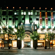 An exterior view of the large three storey architecture, building, city, condominium, downtown, facade, hotel, landmark, lighting, metropolis, metropolitan area, mixed use, night, black