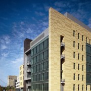 View of a large concrete, steel and glass apartment, architecture, building, commercial building, condominium, corporate headquarters, daytime, facade, headquarters, house, landmark, metropolis, metropolitan area, mixed use, neighbourhood, real estate, residential area, sky, window, blue