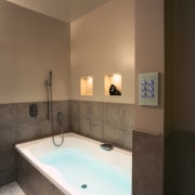 View of a bathroom, grey tiled bath and bathroom, bathtub, floor, interior design, plumbing fixture, property, room, sink, brown, black
