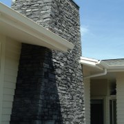 Closeup of exterior schist chimney. - Closeup of architecture, brick, brickwork, building, facade, home, house, roof, siding, sky, wall, window, black, gray