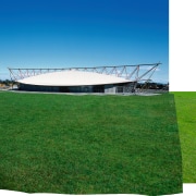 An verall view of the long boat shaped architecture, energy, field, grass, grassland, land lot, lawn, meadow, plant, shade, sky, structure, green