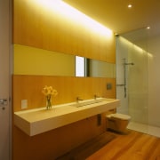 view of the beach house bathroom featuring white architecture, bathroom, ceiling, daylighting, floor, flooring, interior design, lighting, room, sink, wall, brown, orange