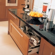 A view of a kitchen, wooden cabinetry, white cabinetry, countertop, cuisine classique, drawer, floor, flooring, furniture, hardwood, home appliance, interior design, kitchen, kitchen appliance, kitchen stove, room, tile, brown, orange, white