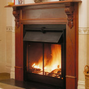 A view of a wooden fireplace surrounded with fire screen, fireplace, hearth, heat, home appliance, wood burning stove, brown