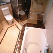 overhead view of the bathtub, showing brown stone bathroom, floor, plumbing fixture, property, room, sink, tile, toilet, toilet seat, orange, brown