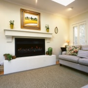 Lounge area with cream walls, large fireplace, fawn fireplace, floor, flooring, hardwood, hearth, home, interior design, living room, real estate, room, wall, wood flooring, white