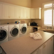 A view of the laundry ara, many white cabinetry, clothes dryer, countertop, home, home appliance, kitchen, laundry, laundry room, major appliance, room, washing machine, brown, orange