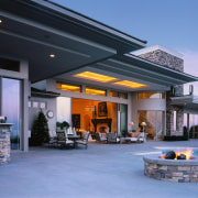 An exterior view of a large concrete house, estate, home, real estate, roof, teal, black